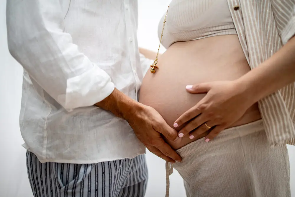foto maternity con le mani di mamma e papà sul pancione
