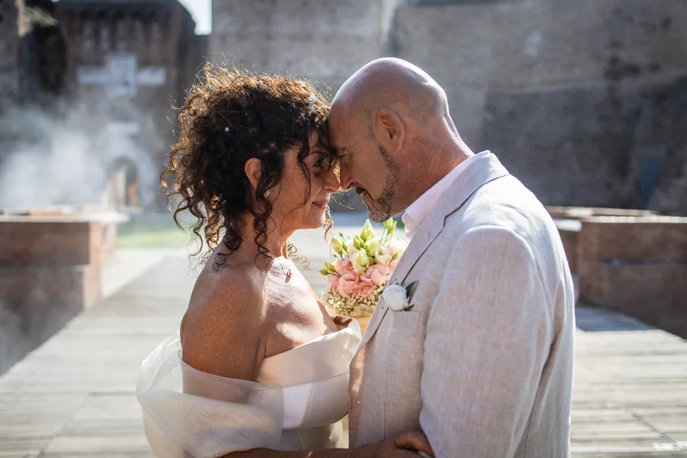 foto matrimonio con gli sposi fronte a fronte davanti al castello