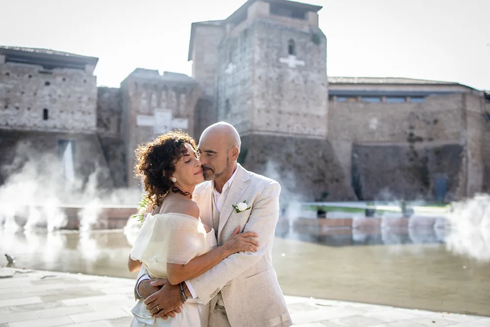 foto matrimonio con gli sposi abbracciati davanti al castello tra la nebbia scenografica
