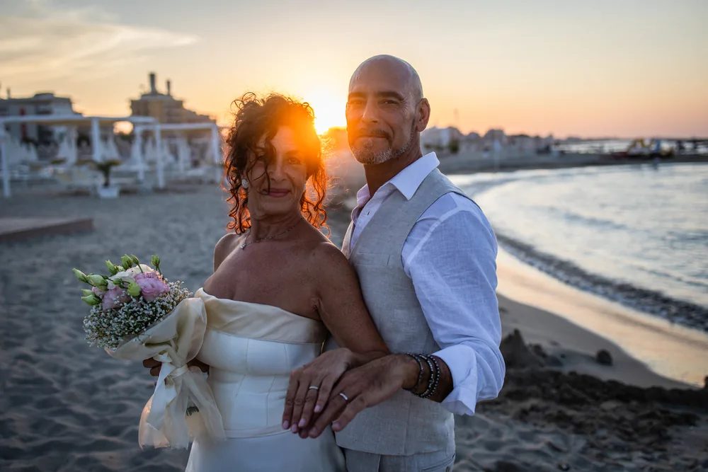 foto matrimonio con gli sposi ritratti insieme al tramonto in spiaggia